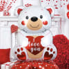 Large teddy bear balloon holding a heart with "love you" text