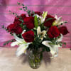 Red roses and white lilies arranged in a glass vase