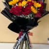 Bouquet of red roses and yellow daisies wrapped in black paper