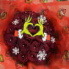 Bouquet of dark red roses wrapped in bright red Grinch-themed paper