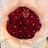 Bouquet of red roses wrapped in pale pink patterned paper