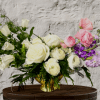 Pink and white roses with purple flowers in a gold vase
