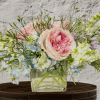 Pastel bouquet of pink and blue flowers in a clear glass vase