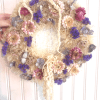 Dried floral wreath with purple and pink flowers on a straw base