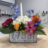 A refined, garden-inspired arrangement featuring a vibrant mix of seasonal blooms in