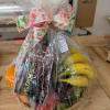 Gift basket with fruit and chocolate wrapped in clear cellophane and a floral ribbon