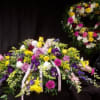 Large mixed floral spray with a matching wreath behind it