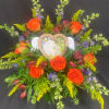 Orange roses arranged around a heart-shaped photo frame