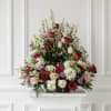 Large arrangement of red, blush, and white roses with mixed filler flowers
