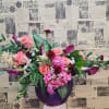 Pink and burgundy floral arrangement in a purple vase