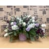Lavender and white floral arrangement in a pink vase