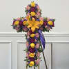 Cross-shaped floral tribute with yellow roses, lilies, and pink and purple flowers