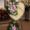 A solid heart with a mixture of pink carnations, pink roses, white