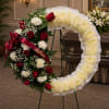 An open wreath with a mixture of white fuji mums, red roses
