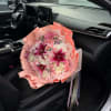 Pink and white bouquet with lilies and roses on a car seat