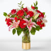 Bouquet of red roses and pink lilies in a glass vase