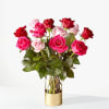 Bouquet of pink and red roses in a glass vase with a gold base