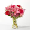 Pink lilies and red roses in a clear glass vase