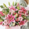 Pink lilies and roses in a hand-tied bouquet