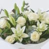 Bouquet of white lilies and roses wrapped in paper