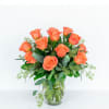 Orange roses arranged in a clear glass vase