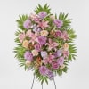 Standing floral spray with pink lilies, roses, and purple blooms