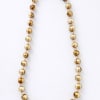 Gold beaded necklace on a white background