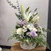 Basket arrangement with white lilies, lavender roses, and white daisies