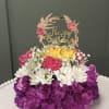 Birthday flower arrangement with a gold topper and purple, white, and yellow blooms