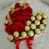Heart-shaped box with red roses, chocolates, and butterflies.
