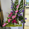 Pink calla lilies and purple bellflowers in a pedestal arrangement