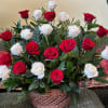 Basket arrangement of red and white roses with palm fronds