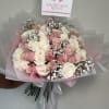 Bouquet of pink and white roses wrapped in pink paper