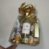 Gift basket with wine bottles, chocolates, and a gold bow