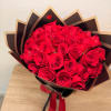 Bouquet of red roses wrapped in dark paper with a red ribbon
