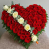 A dramatic heart-shaped rose arrangement built from densely packed red roses with