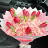 A dense cluster of pale pink roses paired with upright red tulips