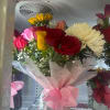 Deep red roses and bright pink blooms mingle with a single sunny