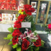 Tall arrangement of red roses and pink lilies with greenery