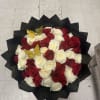 Bouquet of red and white roses wrapped in black paper with gold butterfly picks