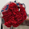 Bouquet of red carnations wrapped in clear plastic with blue ribbon