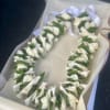 White floral lei in a gift box with a ribbon