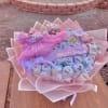 Pink baby gift bouquet with folded clothes and ribbons
