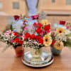 Three colorful flower arrangements in small vases on a table