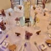 Round banquet table with small floral centerpieces and a tall orchid vase