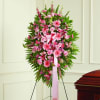 Pink floral standing spray on an easel with a ribbon