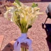 Bouquet of white calla lilies tied with a white ribbon
