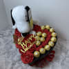 Heart-shaped gift box with red roses, chocolates, and a Snoopy plush