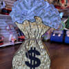 Money bag-shaped gift display with faux dollar bills and a large dollar sign