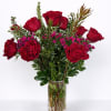 Red roses and pink filler flowers in a clear glass vase